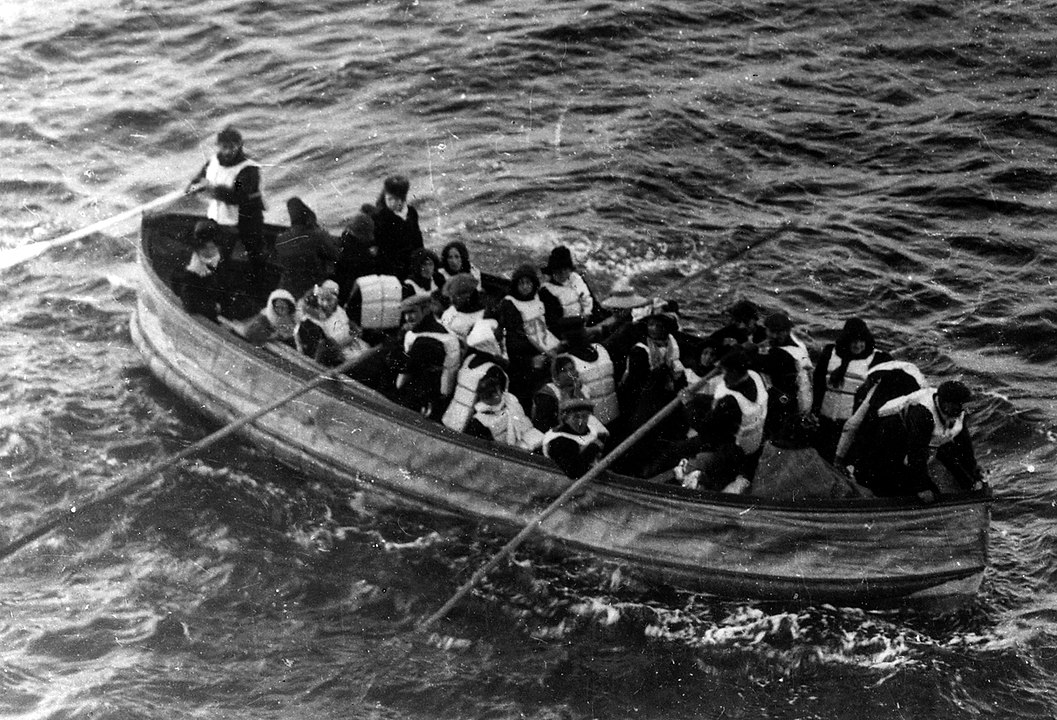 Lifeboats being launched from the sinking Titanic